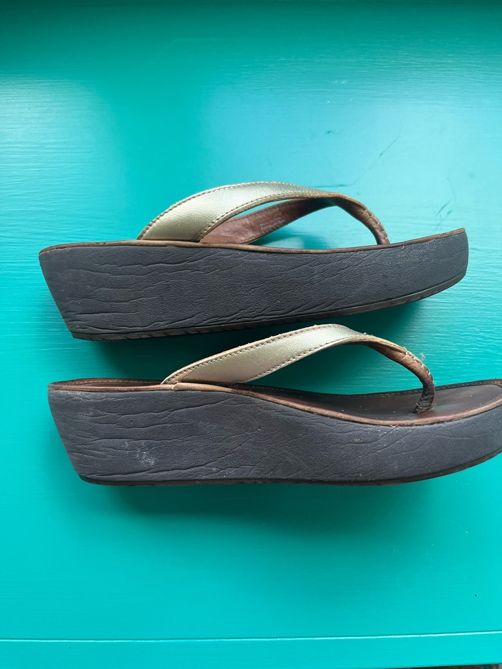 OluKai Wedge Flip Flop Sandals in Metallic Gold